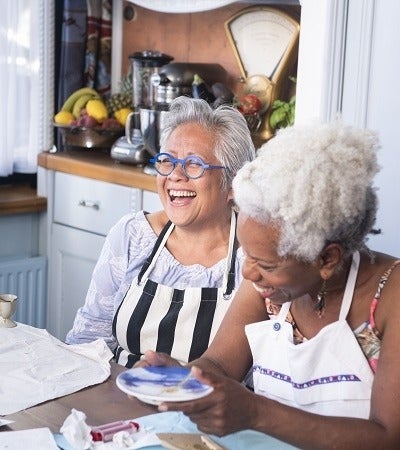 Two women laughing at a painting party